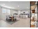 Bright, open-concept dining area with a wooden table and kitchen island with barstool seating at 22570 N Lynn St, Maricopa, AZ 85138