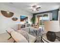 Cozy living room with a TV, ceiling fan, stylish furniture, and sliding glass door to the backyard at 22570 N Lynn St, Maricopa, AZ 85138
