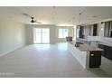 Open-concept living space with tile floors, island kitchen with granite countertops, and patio access at 24183 N 196Th Ln, Surprise, AZ 85387