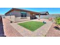A patio with artificial grass complemented by paved walkways and a well-maintained outdoor space at 35175 W Marin Ave, Maricopa, AZ 85138