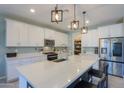 Bright kitchen with stainless steel appliances, a large island, and modern lighting fixtures at 35175 W Marin Ave, Maricopa, AZ 85138
