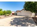 Charming home featuring a well-maintained lawn, two-car garage, and a warm, inviting facade at 4335 E Enrose St, Mesa, AZ 85205