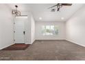 Bright living room featuring neutral walls, carpet flooring, a ceiling fan, and natural light at 4335 E Enrose St, Mesa, AZ 85205