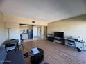Bright living room featuring wood-look floors, and an open floor plan to a kitchen at 4750 N Central Ave # R3, Phoenix, AZ 85012