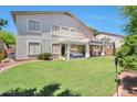 Expansive backyard featuring lush green lawn, patio, and covered seating area at 6027 N 132Nd Dr, Litchfield Park, AZ 85340