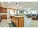 Well-lit kitchen featuring an island with a sink and a view into the living room at 6027 N 132Nd Dr, Litchfield Park, AZ 85340