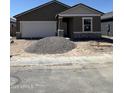 New home under construction with a neutral color palette, stone accents, and an attached two-car garage at 6057 E Artemis Dr, Florence, AZ 85132