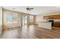 Bright living room featuring wood floors, fan, natural light, and access to the backyard at 6103 S 54Th Ave, Laveen, AZ 85339