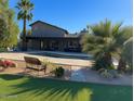 This backyard features a gorgeous pool surrounded by patio, lush green grass, and mature palm trees at 6408 E Gary Rd, Scottsdale, AZ 85254