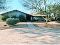 Inviting single-story home featuring a well-manicured front yard and brick walkway to the entrance at 6408 E Gary Rd, Scottsdale, AZ 85254