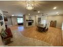 Open living room with a fireplace and wood floors and a chandelier at 6408 E Gary Rd, Scottsdale, AZ 85254