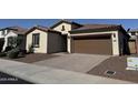 Charming single-story home featuring desert landscaping, a brown garage door, and a tile roof at 7046 N 84Th Dr, Glendale, AZ 85305