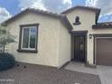 Charming single-story home featuring desert landscaping, a brown garage door, and a tile roof at 7046 N 84Th Dr, Glendale, AZ 85305