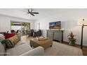 Inviting living room with neutral decor, ceiling fan, and sliding glass door at 7630 E Pasadena Ave, Scottsdale, AZ 85250