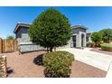 Landscaped front yard with mature tree, decorative rock, and well-maintained exterior at 7824 S 33Rd Ln, Laveen, AZ 85339