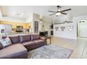 Open-concept living room featuring tile flooring, a comfortable sectional sofa, and seamless flow into the kitchen at 10138 W Oregon Ave, Glendale, AZ 85307