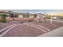 Inviting single-story home with desert landscaping, brick accents, and a welcoming entrance with security door at 10620 W Clair Dr, Sun City, AZ 85351