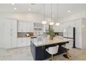 Bright modern kitchen with large island, stylish pendant lighting, stainless steel appliances, and white cabinetry at 1070 S Amber St, Chandler, AZ 85286