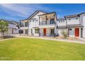 View of new townhome featuring a vibrant green lawn, balcony, and striking white facade at 11300 N Casa Dega Dr # 1090, Surprise, AZ 85388