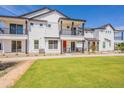 Newly built townhome with modern white siding, a balcony, and a well-maintained green lawn at 11300 N Casa Dega Dr # 1090, Surprise, AZ 85388