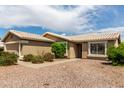 Inviting single-story home with desert landscaping, large windows and a walkway leading to the front door at 11520 W Lizard Ct, Surprise, AZ 85378