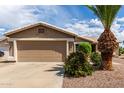 Charming single-story home with a two-car garage, desert landscaping, and a well-maintained front yard at 11520 W Lizard Ct, Surprise, AZ 85378