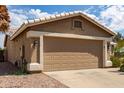 Spacious two-car garage featuring a neutral color door and well maintained desert landscaping around at 11520 W Lizard Ct, Surprise, AZ 85378