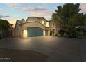 Home featuring a three-car garage, and desert landscaping at 14430 W Windsor Ave, Goodyear, AZ 85395