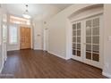 Bright foyer featuring wood flooring, a decorative chandelier, and glass French doors at 1506 W Laurel Ave, Gilbert, AZ 85233