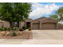 Charming home featuring desert landscaping, mature tree and a two-car garage at 18359 W Sweet Acacia Dr, Goodyear, AZ 85338
