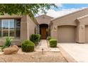 A lovely desert landscaped front entrance with stone walkway and mature plants at 18359 W Sweet Acacia Dr, Goodyear, AZ 85338