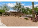 Low maintenance desert landscaping with mature trees and gravel in the front yard at 18359 W Sweet Acacia Dr, Goodyear, AZ 85338
