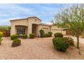 Inviting single-story home featuring well-maintained landscaping and a cozy front porch seating area at 18415 W Capistrano Ave, Goodyear, AZ 85338