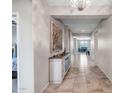 Bright hallway featuring tile flooring and decorative lighting fixtures leading to various living spaces at 18662 W Foothill Dr, Surprise, AZ 85387