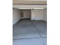 Spacious and clean two-car garage with white walls and concrete flooring; includes a convenient service door at 18795 E Bruno Dr, Gold Canyon, AZ 85118