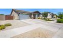 Front exterior view of a single-story home with well-kept lawn and a two-car garage at 22262 E Cherrywood Ct, Queen Creek, AZ 85142