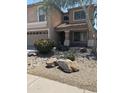 Charming home with desert landscaping, flowering bushes, rocks, and a two-car garage at 2411 W Lucia Dr, Phoenix, AZ 85085