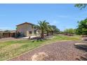 Expansive backyard features desert landscaping and rock, mature trees and a covered patio at 2726 S 160Th Ave, Goodyear, AZ 85338