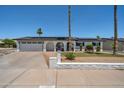 Charming one-story home featuring a well-maintained front yard, a two car garage, and solar panels at 2820 E Surrey Ave, Phoenix, AZ 85032