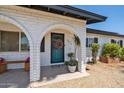 Inviting covered porch with a teal door, a wreath, potted plants and a wooden bench at 2820 E Surrey Ave, Phoenix, AZ 85032