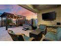 Inviting covered patio featuring a hot tub, outdoor seating, a mounted TV and string lights for relaxing evenings at 2915 W Night Owl Ln, Phoenix, AZ 85085
