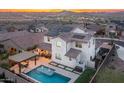 A white two-story home with solar panels, desert landscaping, and a backyard pool with spa and seating at 2915 W Night Owl Ln, Phoenix, AZ 85085