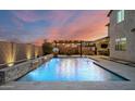 Beautiful backyard pool featuring a waterfall feature, basketball hoop, hot tub, and ambient lighting at 2915 W Night Owl Ln, Phoenix, AZ 85085