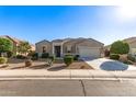 Charming single-story home with desert landscaping, mature trees, and a two-car garage at 30089 W Rockmount Ave, Buckeye, AZ 85396