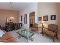 Bright living room with neutral carpet, ornate furniture, and an archway leading to the dining area at 31017 N 41St Pl, Cave Creek, AZ 85331
