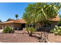 This home features desert landscaping with rocks, cactus, and mature trees in the front yard at 4316 E Janice Way, Phoenix, AZ 85032