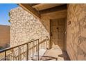 Exterior view of a condo entrance featuring a textured wall and covered entry on the second level at 4950 N Miller Rd # 233, Scottsdale, AZ 85251