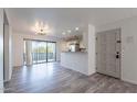 Inviting living area with wood flooring, a kitchen view, and a sliding glass door to the balcony at 4950 N Miller Rd # 233, Scottsdale, AZ 85251