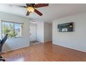 Bright living room featuring hardwood floors, ceiling fan, and a large window at 5305 E Silverbell Rd, San Tan Valley, AZ 85143
