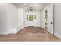 Inviting home foyer with hardwood floors, white walls, and an elegant chandelier over the front door at 5440 E Calle Camelia --, Phoenix, AZ 85018